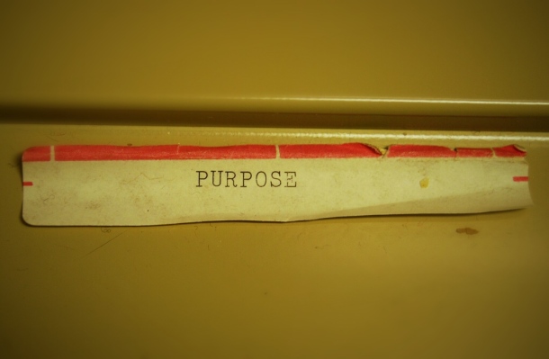 A worn label that reads "PURPOSE" at the bottom of a file.